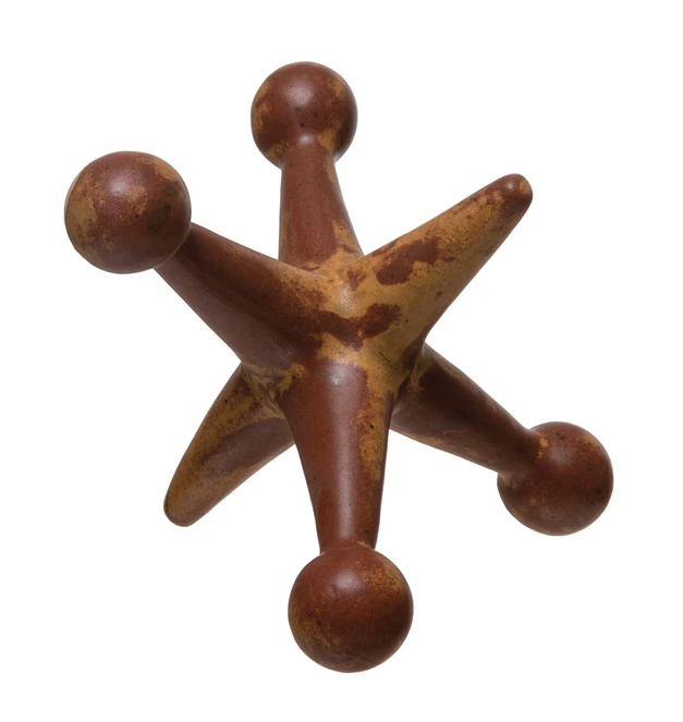A wooden jack with a star shape, painted in brown color, used as a decorative item.